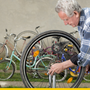 older man restoring a bicycle with his sleeves rolled up