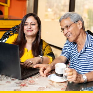 woman and her father smiling at a laptop screen