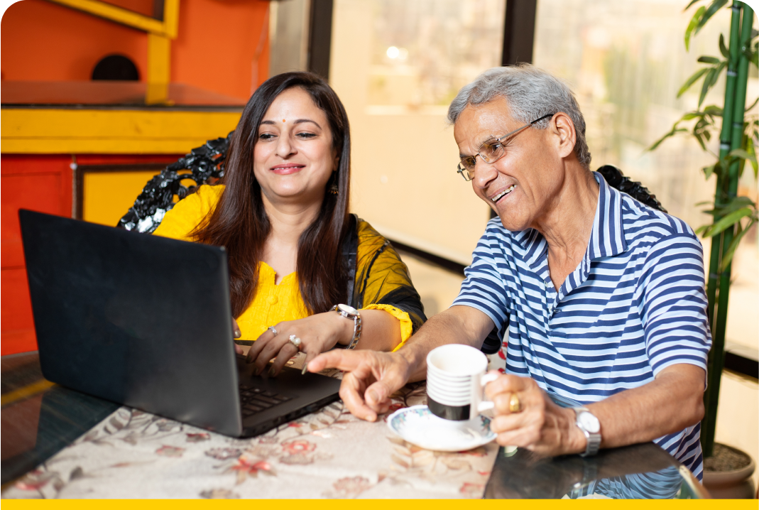 woman and her father smiling at a laptop screen 