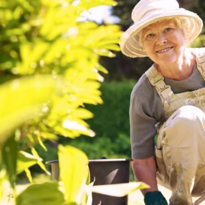 Older woman smiling while gardening in the sun