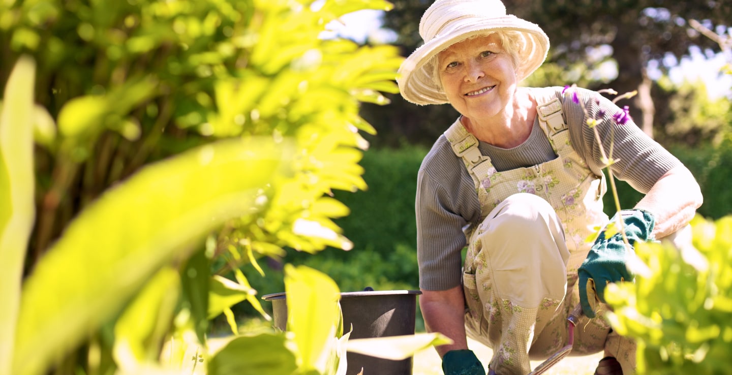 Older woman smiling while gardening in the sun