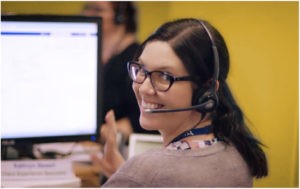Care connect team member smiling for a photo while working at her desk