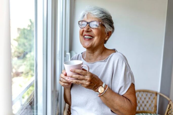 Senior woman drinking a beverage at home